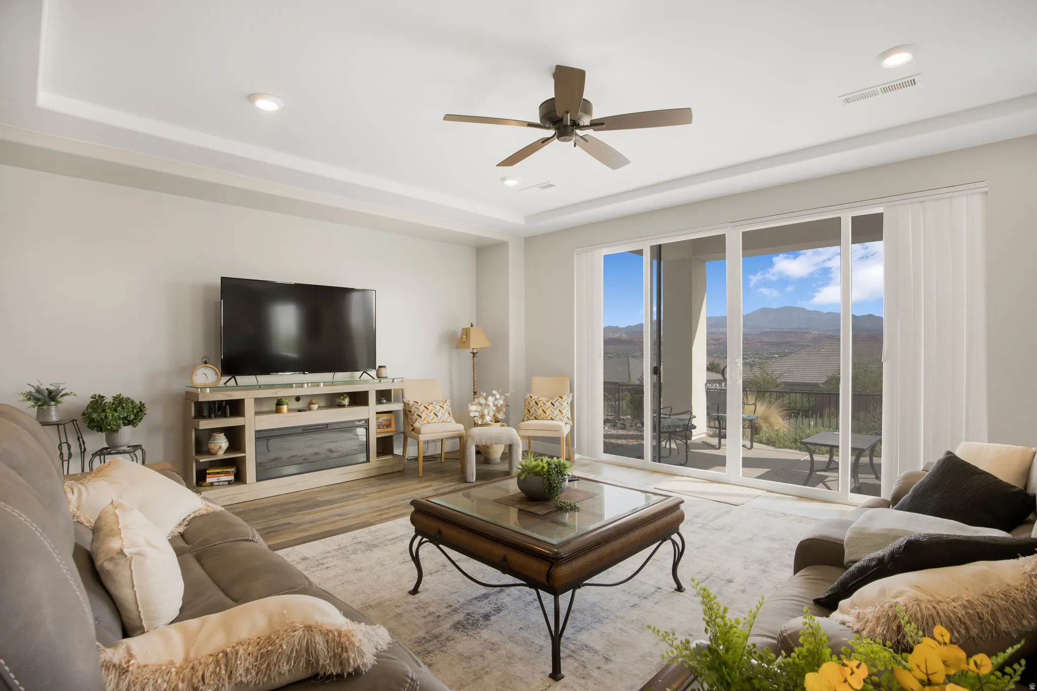 Recessed lighting, a ceiling fan, and wood-finish flooring define this space
