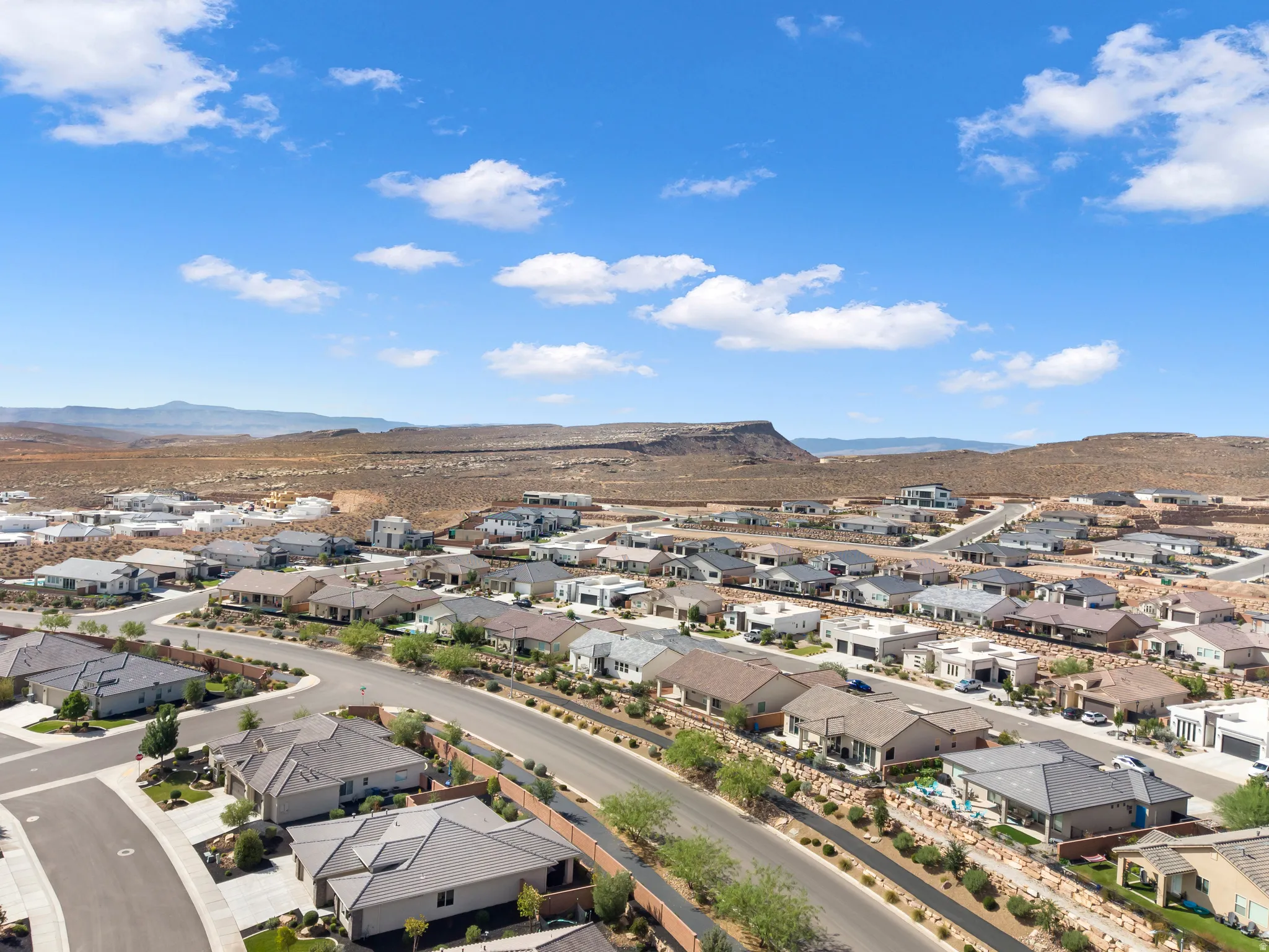 Residential neighborhood with varied architectural styles situated against a desert landscape