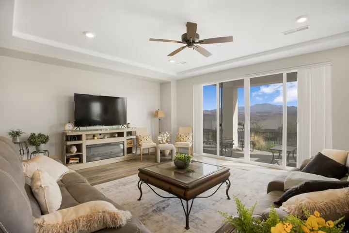 Recessed lighting, a ceiling fan, and wood-finish flooring define this space
