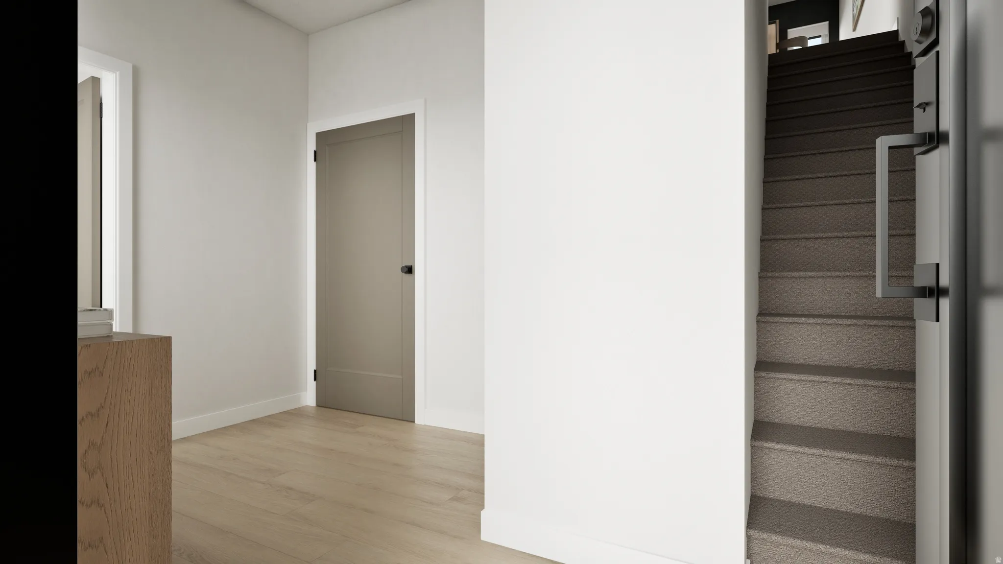 Wood-finish flooring with a neutral wall color, white trim, and a paneled interior door with matte black hardware