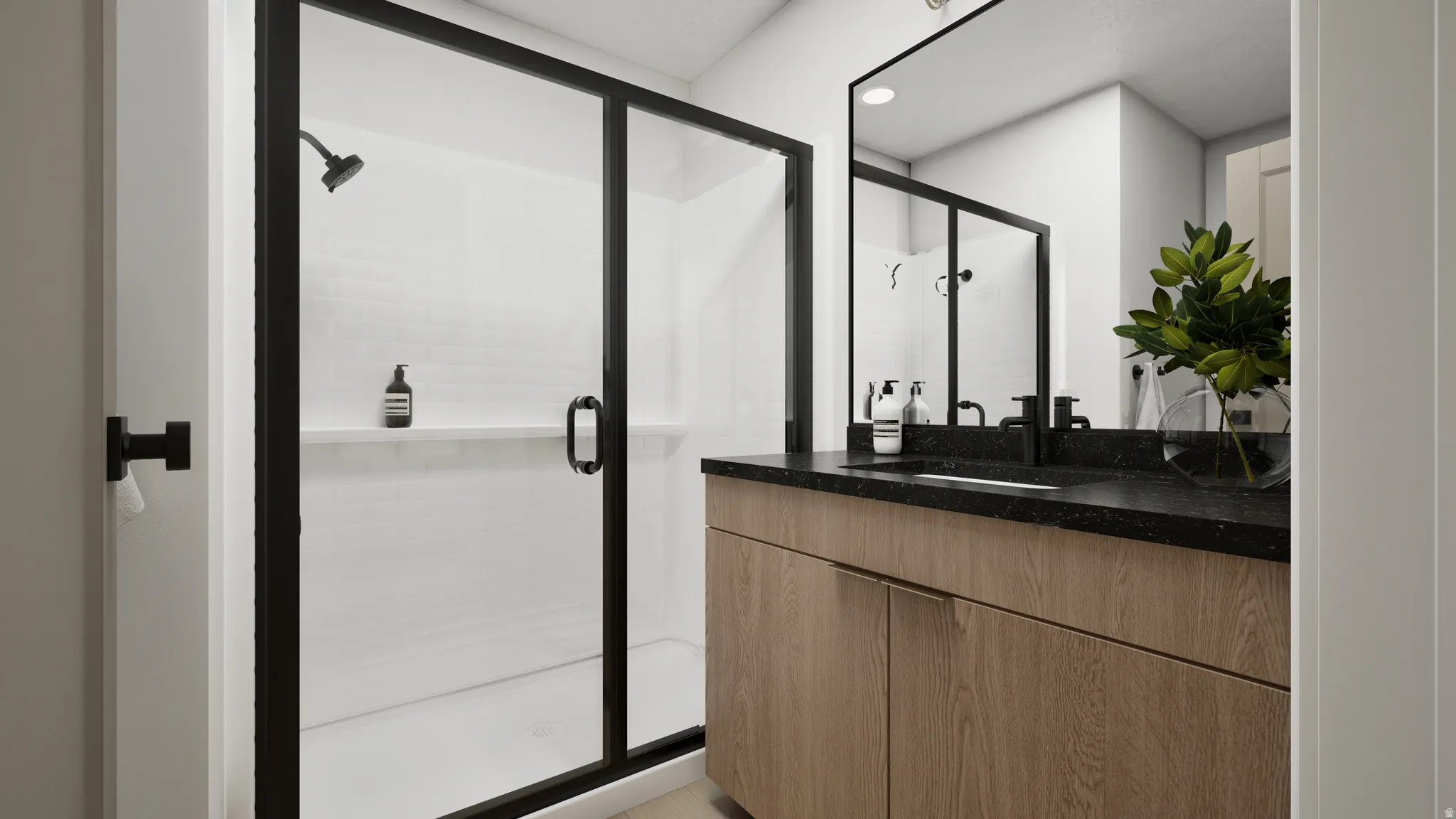 Walk-in shower with black-framed glass enclosure, black shower fixtures, wood-finish vanity, black countertop, and black-framed mirror