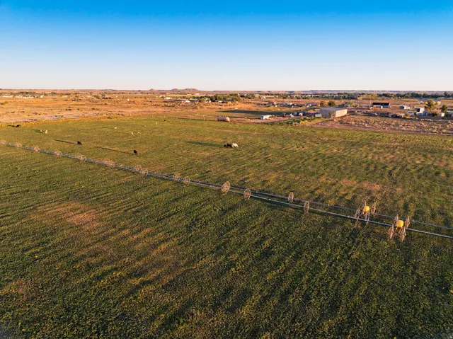 Expansive agricultural land featuring a verdant field and irrigation equipment