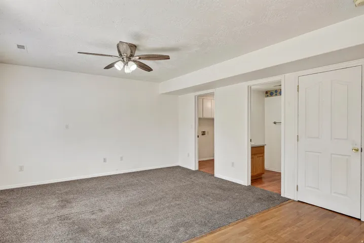 Recessed ceiling fan, neutral wall paint, gray carpeting, wood-finish flooring, and panel doors