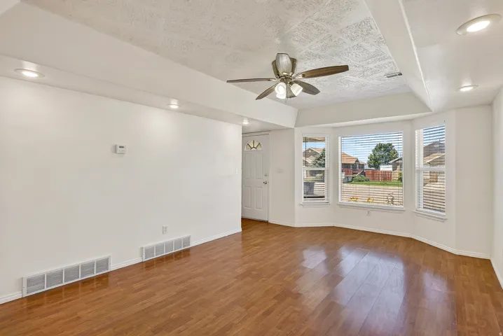 Wood-finish flooring, recessed lighting, and a ceiling fan with light fixture