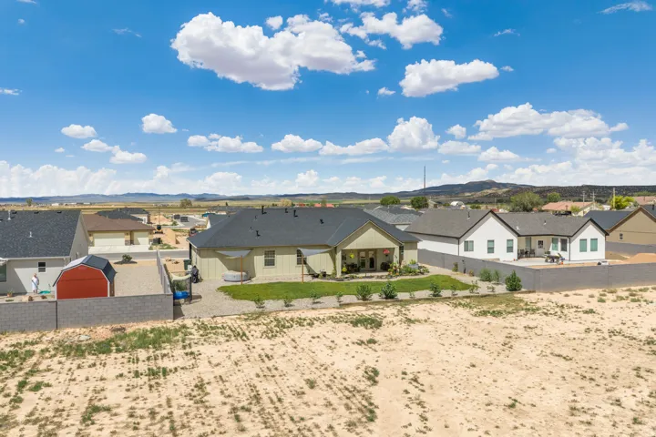 Expansive backyard featuring a manicured lawn, established landscaping, and privacy fencing