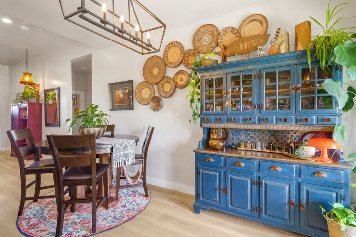 Elegant dining area featuring a round wood table with upholstered chairs, positioned on a patterned area rug