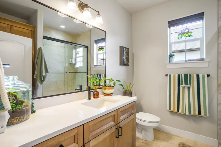 Bathroom vanity with a rectangular undermount sink, a bronze-finish faucet, and a quartz countertop