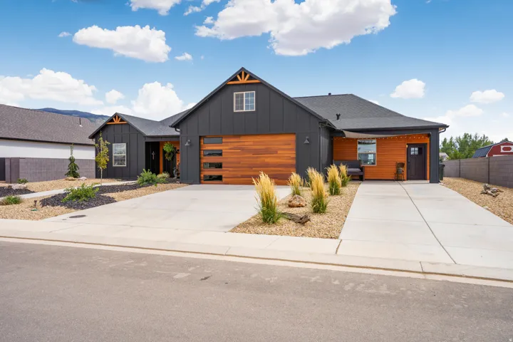 Modern farmhouse exterior with dark siding and wood-finish accents