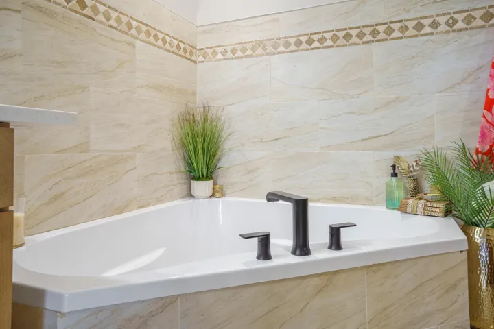 Spa-inspired primary bathroom featuring a luxurious soaking tub with a three-hole matte black faucet and lever handles