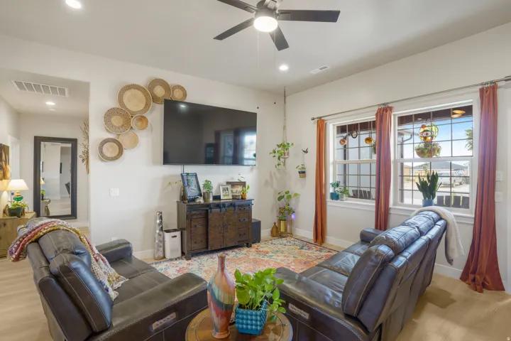 Recessed lighting, ceiling fan, wood-finish flooring, and multiple windows with white trim