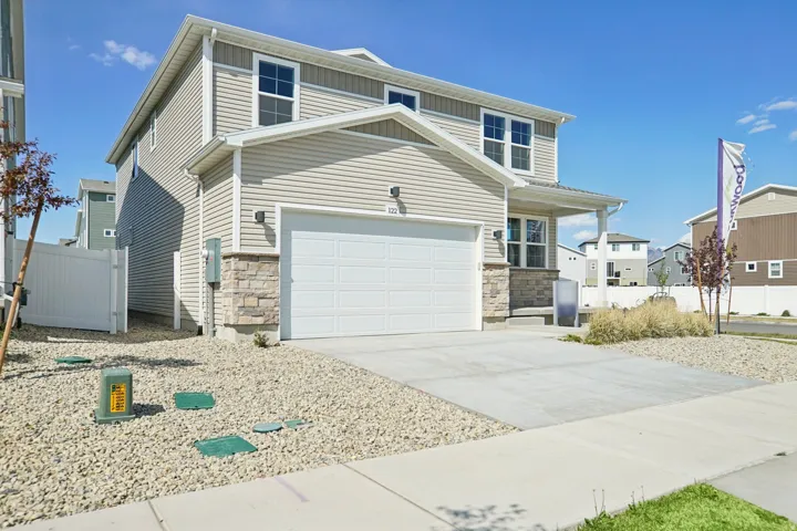 Two-story residence featuring light-colored siding, a covered front porch, and a two-car garage
