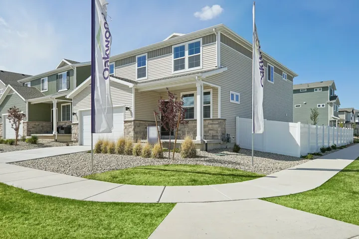 Two-story residence featuring light-colored siding and stone accents