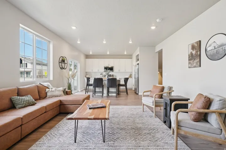 Open-concept living area featuring wood-finish flooring, recessed lighting, and large windows