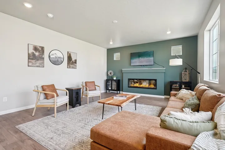 Recessed lighting, wood-finish flooring, accent wall, linear electric fireplace, and multiple windows