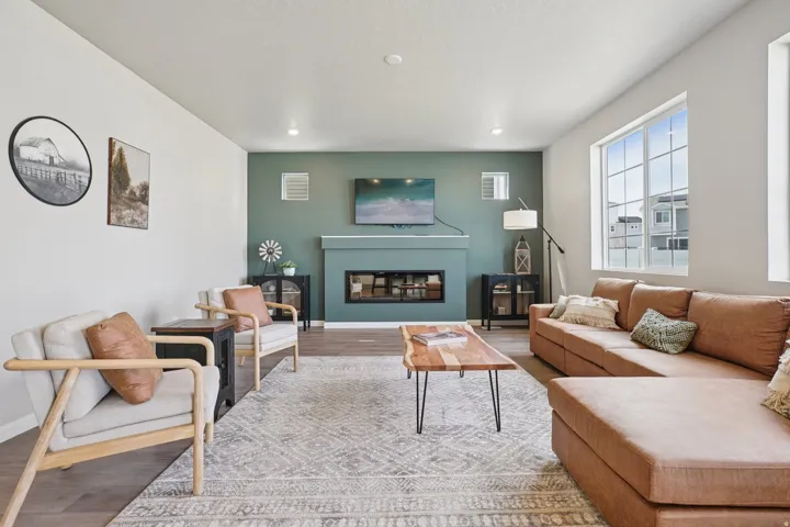 Living room featuring wood-finish flooring, a built-in fireplace with a mantel, and recessed lighting