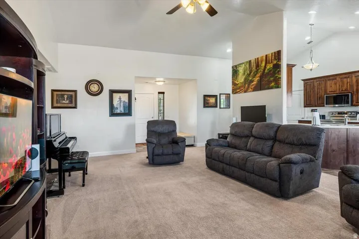 Vaulted ceiling with an overhead fan and recessed lighting