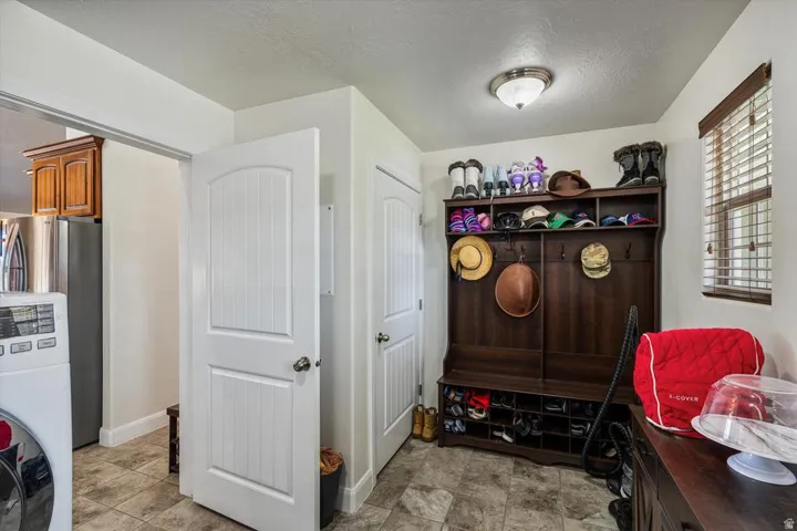 Laundry area with tile flooring and a built-in wood-finish storage unit