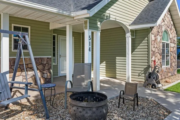 Stone accent siding, vinyl siding, arched front entryway, exterior lighting fixture, asphalt shingle roof