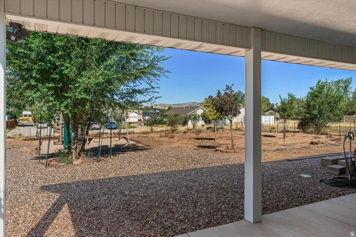 Covered patio with a gravel yard and mature trees