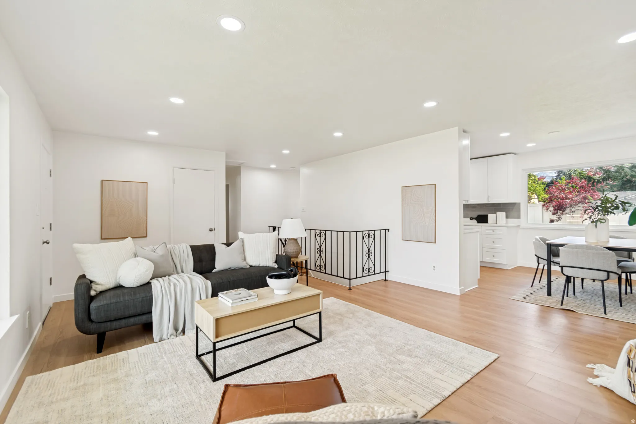 Recessed lighting illuminates wood-finish flooring throughout the space