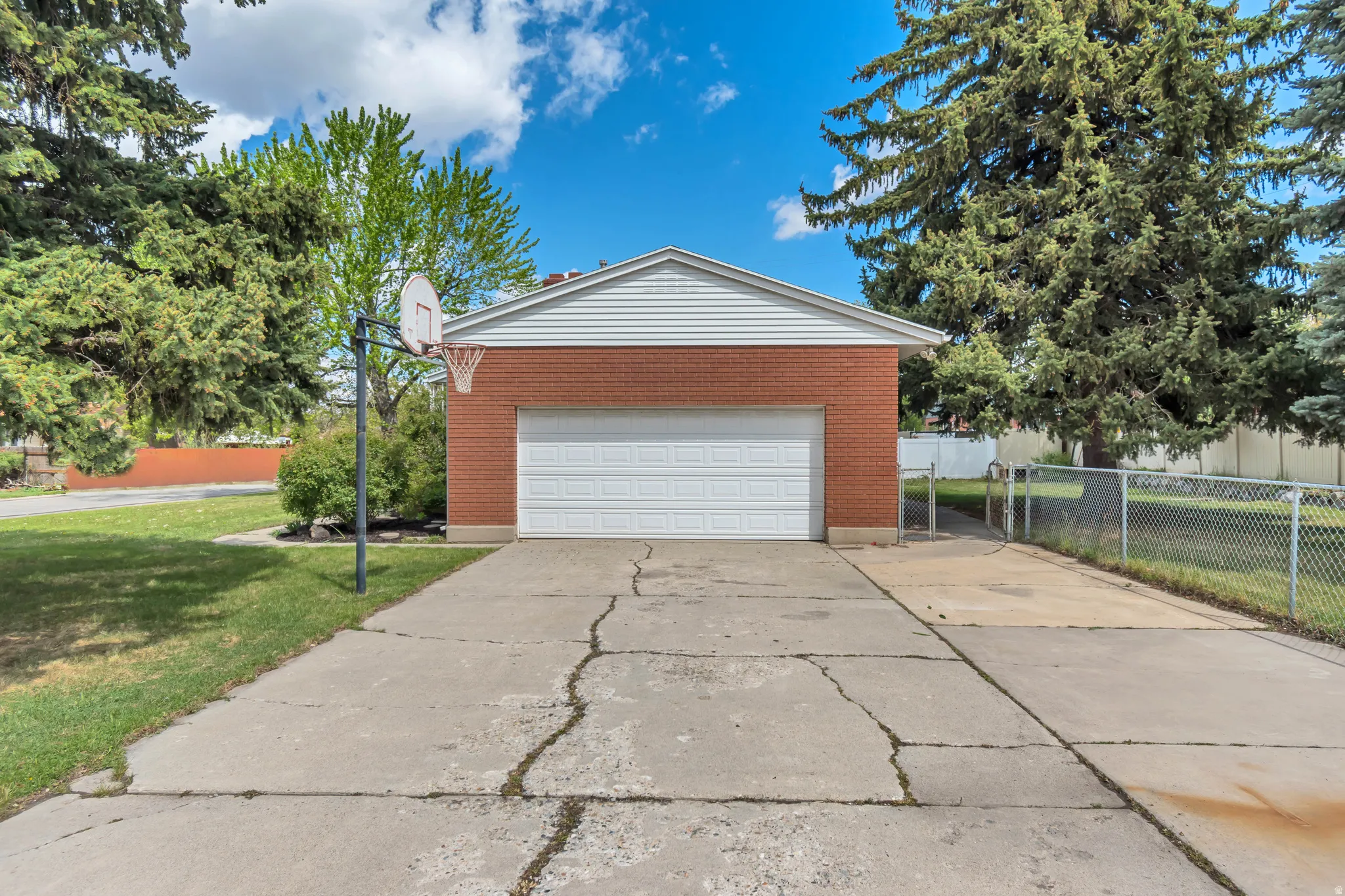 Attached garage with brick exterior and white siding