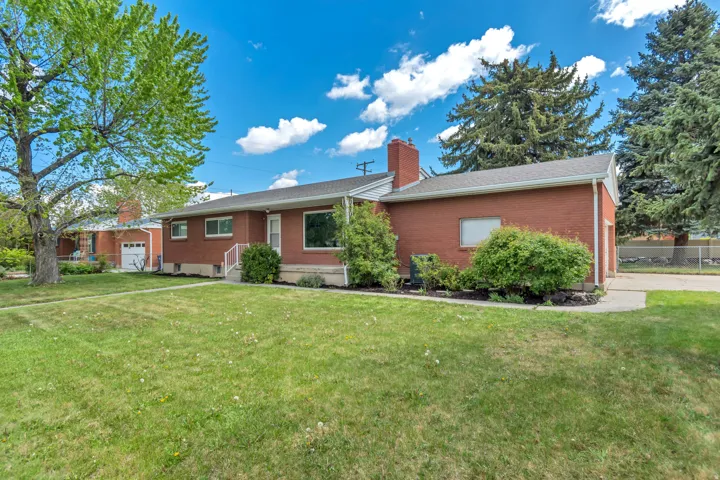 Brick exterior, attached garage, well-maintained lawn, mature trees, concrete driveway