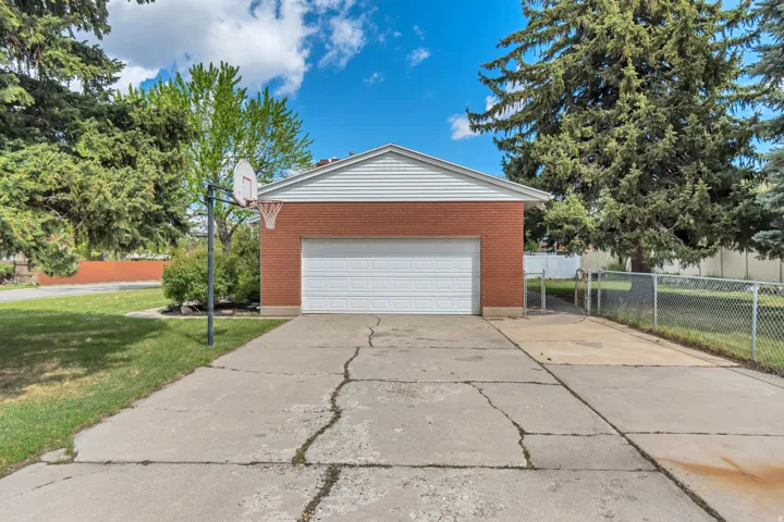 Attached garage with brick exterior and white siding