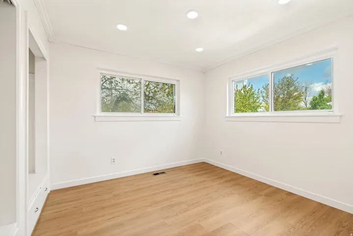 Wood-finish flooring, recessed lighting, and built-in cabinetry featuring drawer pulls