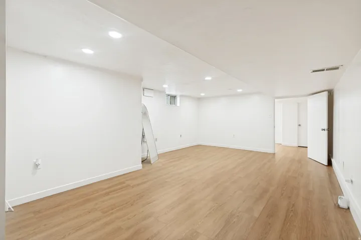 Recessed lighting, wood-finish flooring, white walls, and white trim
