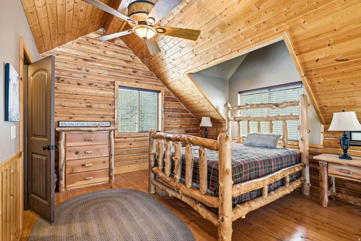 Vaulted wood-paneled ceiling, wood-plank flooring, and horizontal wood-paneled walls