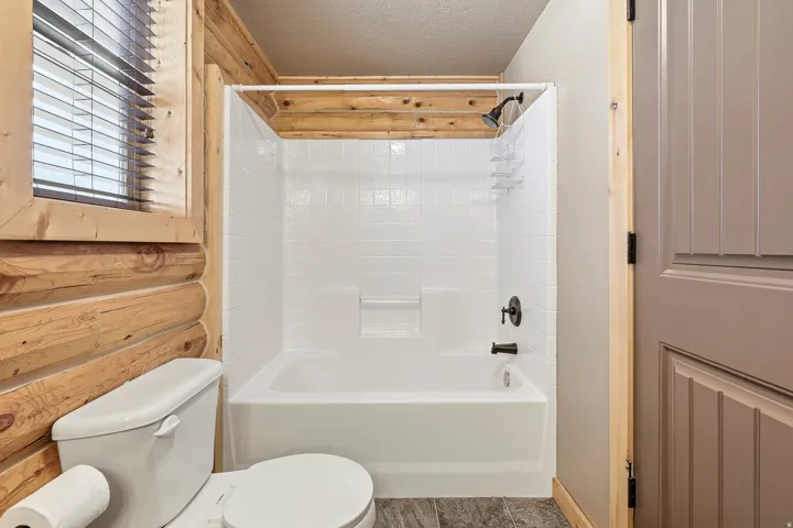 White subway tile shower surround with a built-in tub and dark bronze fixtures