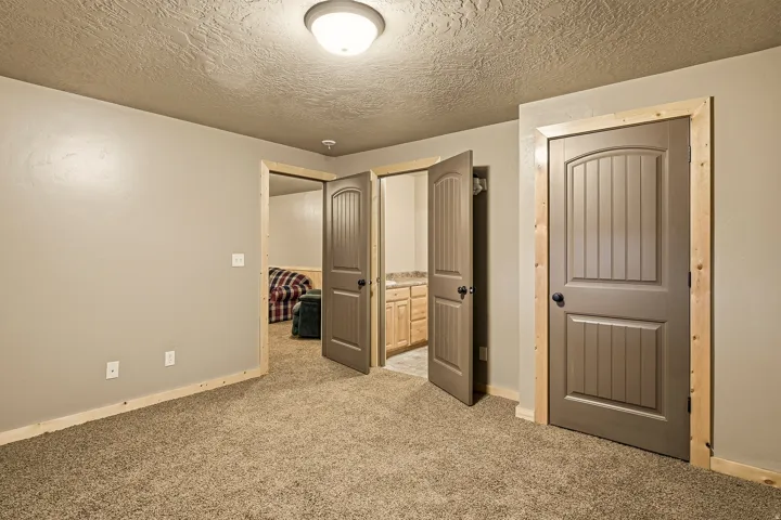 Carpeted room with neutral wall paint and wood trim
