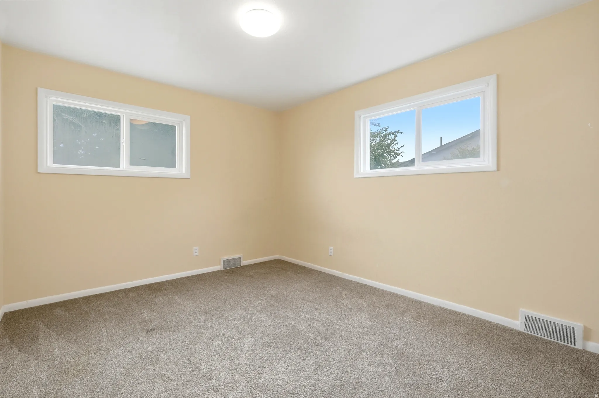 Recessed ceiling lighting, light-colored carpeting, and light-toned wall paint