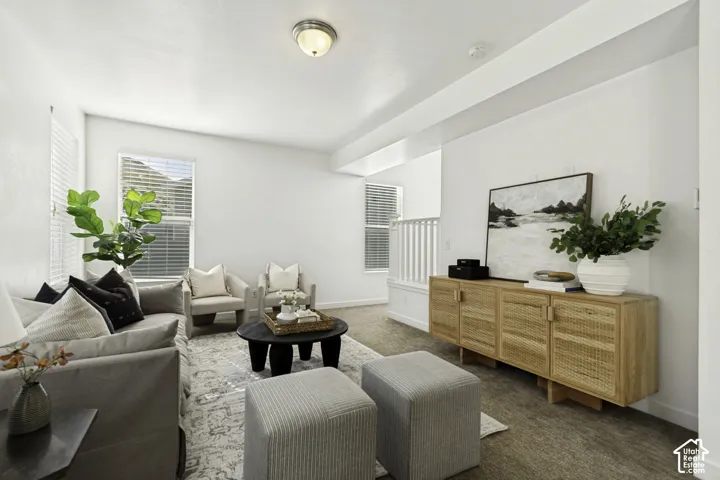 Spacious living area featuring ample natural light, neutral wall colors, recessed lighting, and carpeting