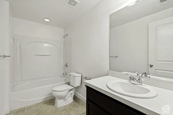 Bathroom featuring a built-in tub with shower, single vanity with an oval sink, and a large wall-mounted mirror