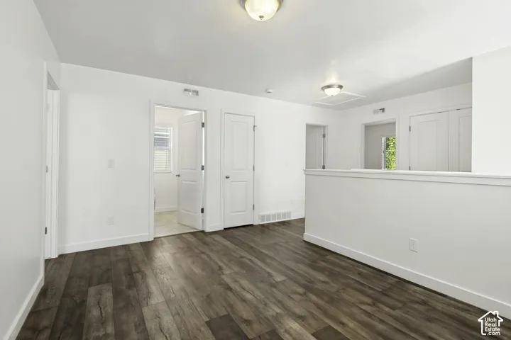 Wood-finish flooring, white walls, white trim, and flush mount lighting
