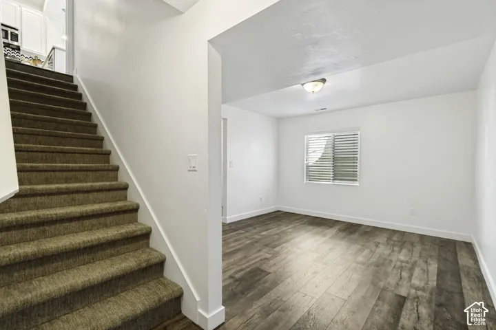 Hardwood-style flooring, white window blinds, and overhead lighting