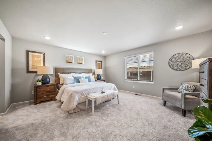 Recessed ceiling lighting, textured wall-to-wall carpeting, window with horizontal blinds, and neutral wall tones