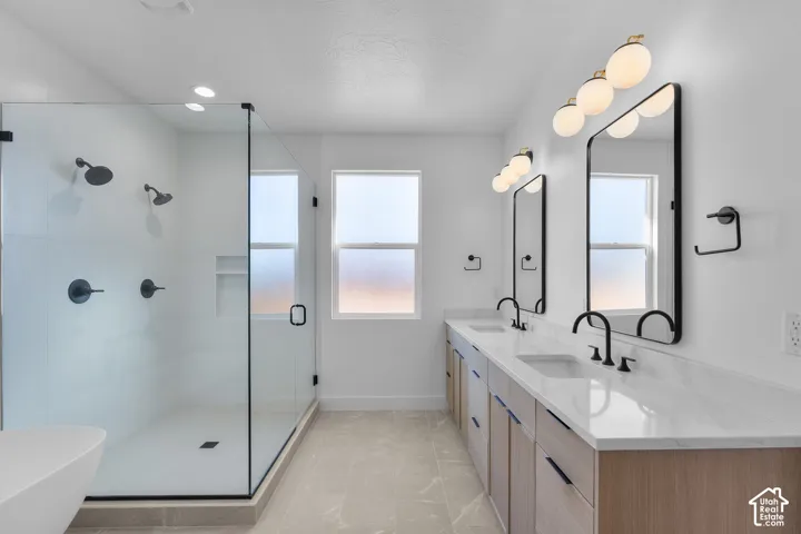 Dual vanity with stone countertops and undermount sinks, matte black fixtures, and framed mirrors