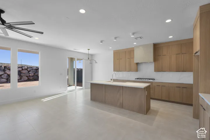 Open concept living area with light-toned tile flooring, recessed lighting, and a modern ceiling fan