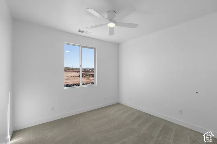 Neutral wall tones, carpeted flooring, a single window, and a ceiling fan with integrated lighting