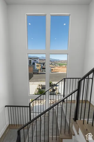 Two-story window feature with black metal railings and natural wood-finish stair treads