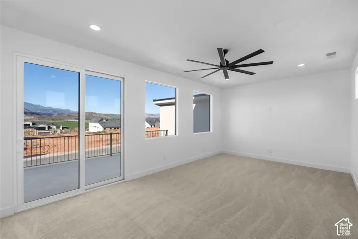 Recessed lighting, ceiling fan with integrated light, multiple windows, sliding glass door, and a private balcony with metal railings