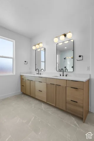 Dual-sink vanity featuring warm wood-finish cabinetry with multiple drawers, white quartz countertop, and polished chrome faucetry