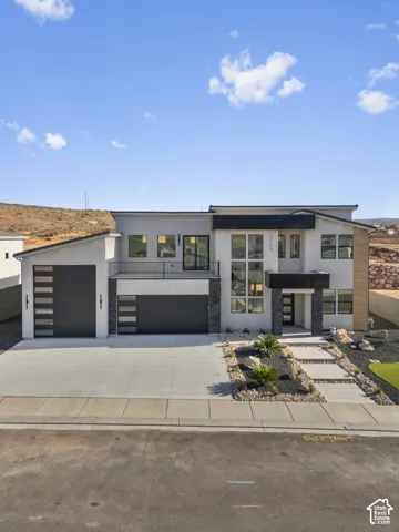 Modern exterior featuring a prominent two-car garage, large windows, and a landscaped front yard with stepping stones