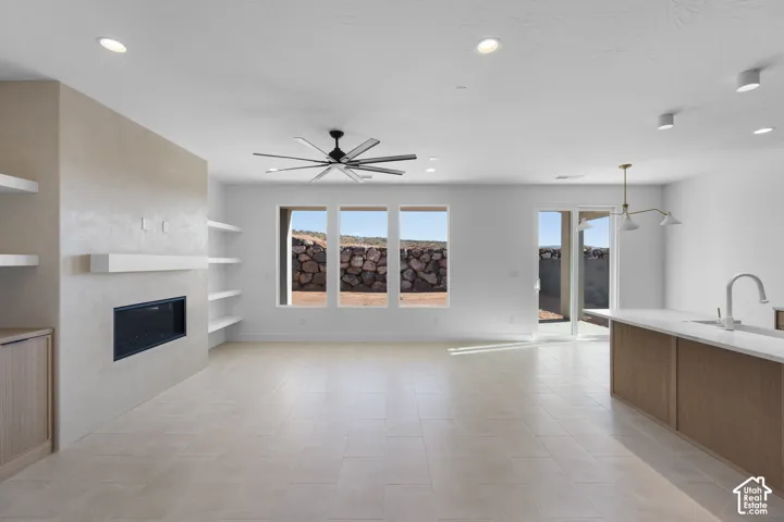 Open-concept living space featuring light-filled interiors with expansive windows and glass doors overlooking desert landscaping