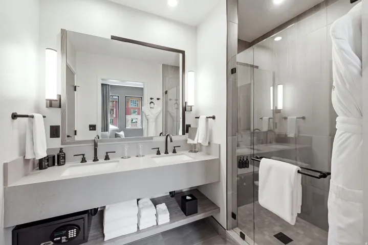 Dual vanity with integrated sinks, matte black fixtures, and sconce lighting