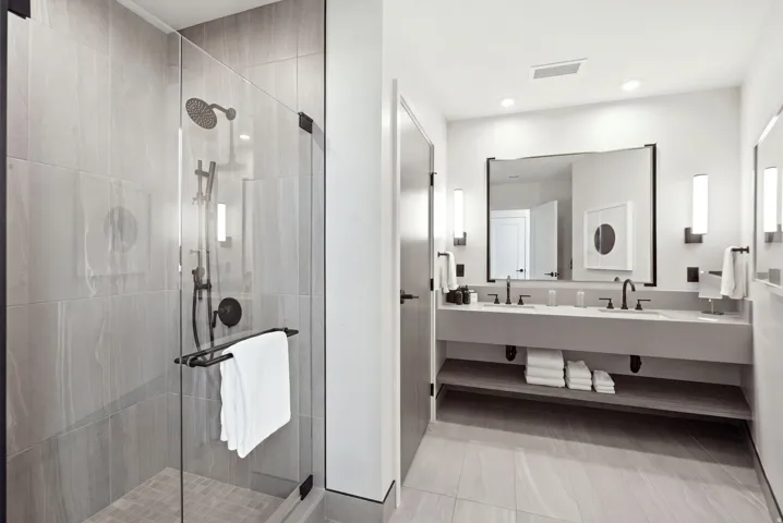 Glass-enclosed shower with dark bronze fixtures and tiled walls