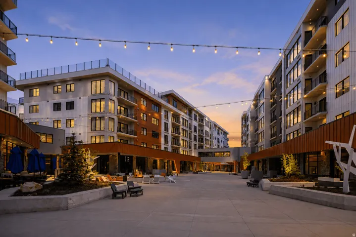 Modern building exteriors with multiple balconies, integrated string lighting, extensive hardscaping, and permanent outdoor seating areas