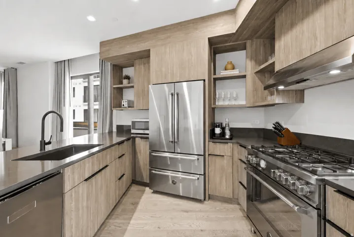 Wood-finish cabinetry and flooring complement dark countertops